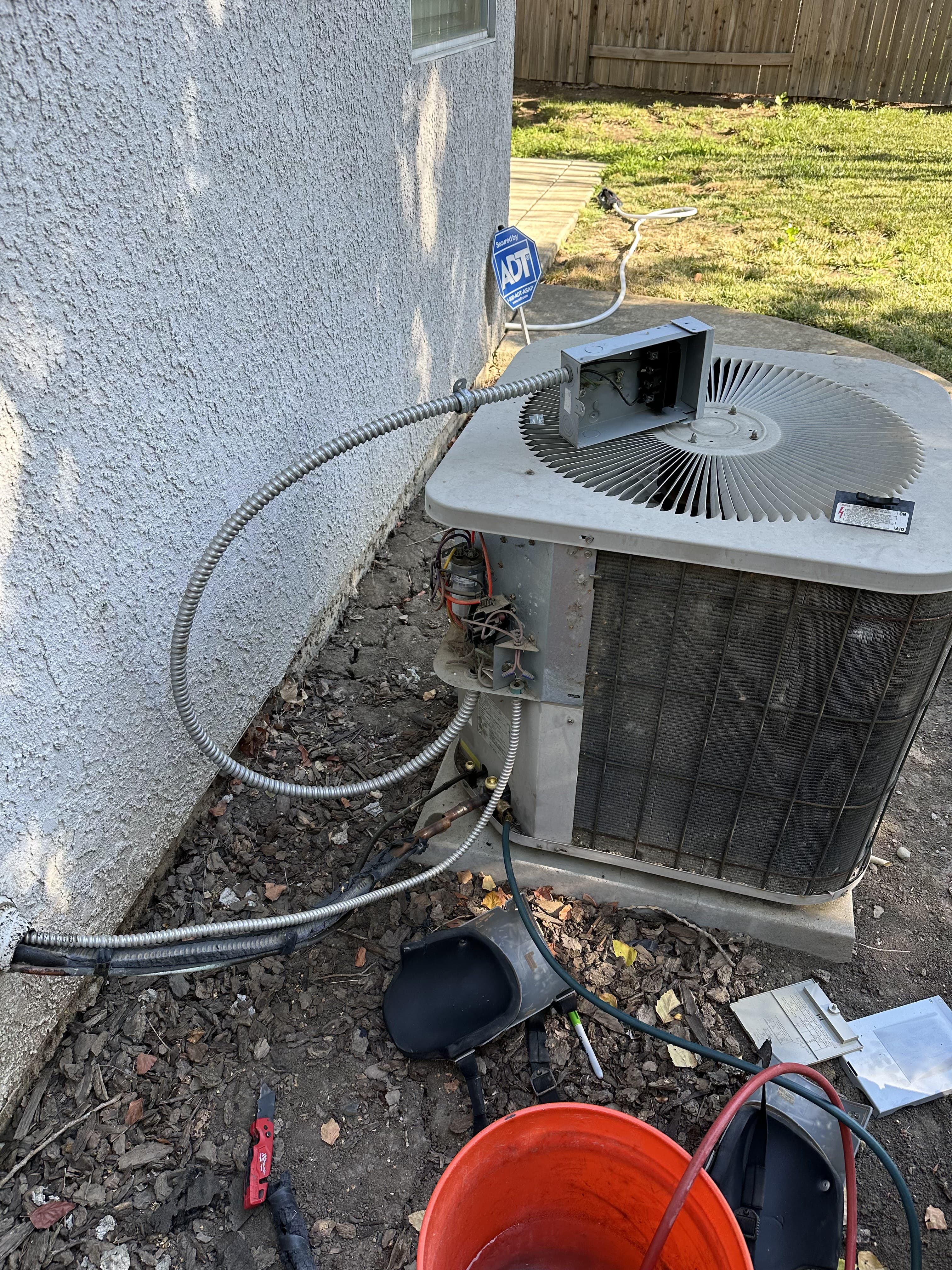 Enright technician servicing an AC unit with side panel removed