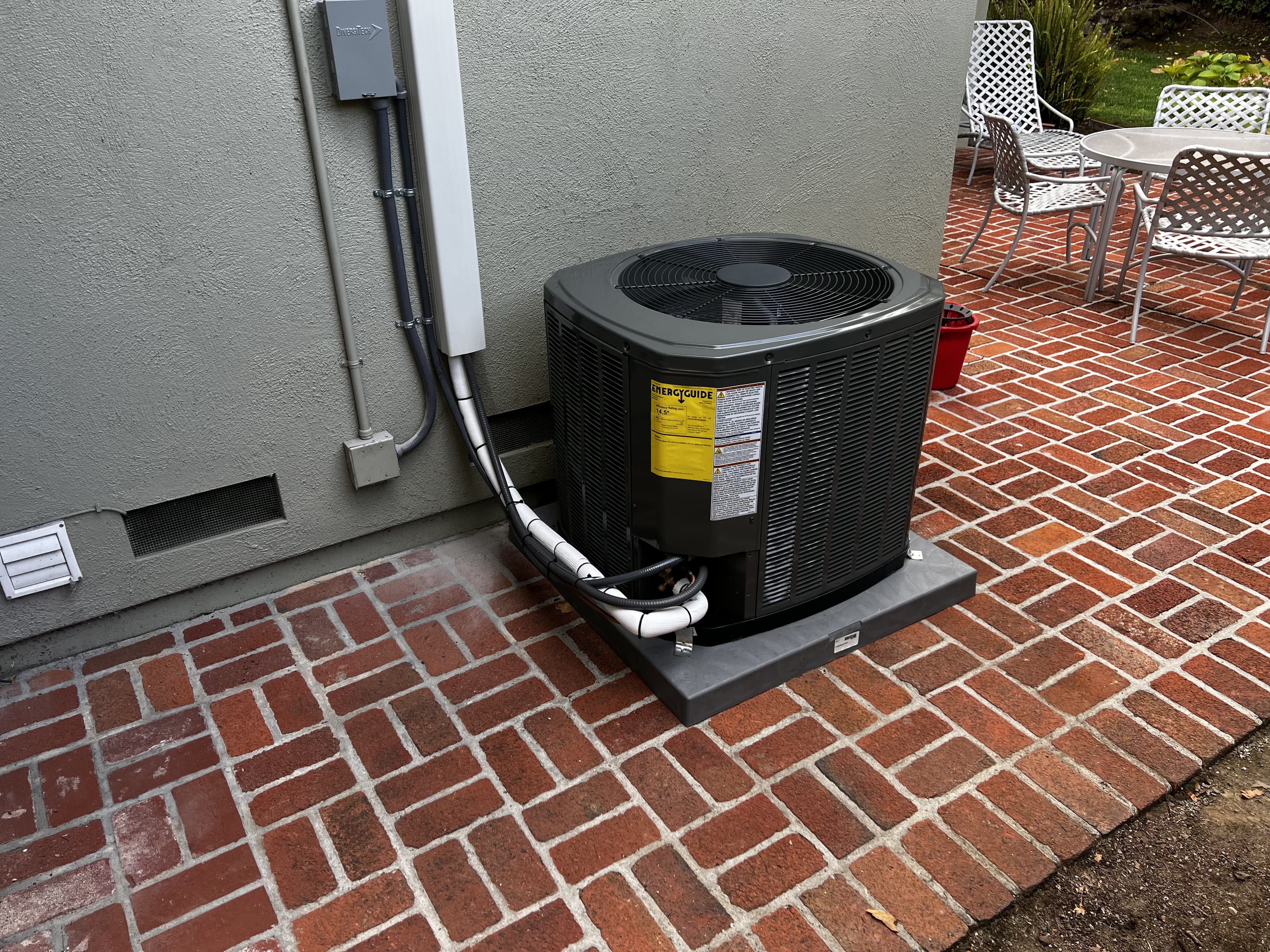Trane air conditioning condenser professionally installed on a brick patio by Enright Heating & Air Conditioning